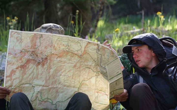 two backpacking students look at a map on an outward bound course in california